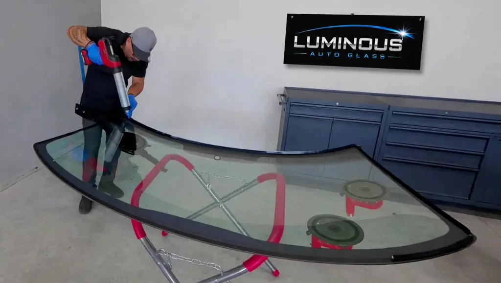 Technician applying urethane to a windshield at Luminous Auto Glass